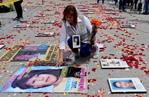 A woman leaves flowers on the photo of a relative on Aug. 30, 2016, in Bogota during the commemoration of the International Day of the Victims of Forced Disappearance. EFE