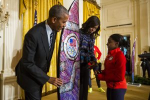 La gimnasta artística estadounidense, Simone Biles (2-d), ofrece una tabla de surf al presidente estadounidense, Barack Obama (i), y a la primera dama de los Estados Unidos, Michelle Obama (d), durante el evento de bienvenida de los atletas del equipo nacional de los Juegos Paraolímpicos 2016 en la Casa Blanca en Washington, Estados Unidos, hoy 29 de septiembre de 2016. EFE