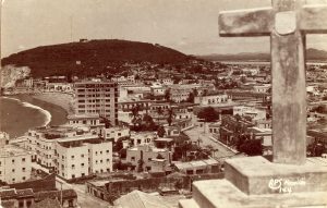 Circa 1940 photo shows sites of two of Mazatlan’s “firsts”: Neveria Hill (rear of picture) and the Hotel Belmar, opened in 1920 on Olas Altas. Photo credit N/A.