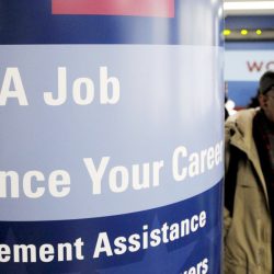 Un hombre pasa al lado de un cartel en el que se detallan los servicios que presta el centro de desempleo Workforce1 Career Center en Brooklyn, Nueva York, EEUU. Imagen de archivo. EFE/Justin Lane